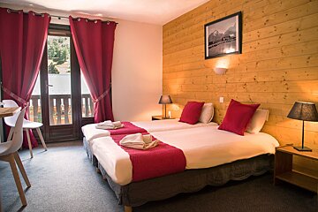 A hotel room with two beds and a picture on the wall