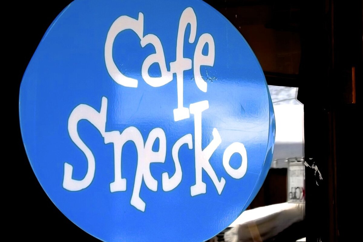 a round blue sign for cafe snesko