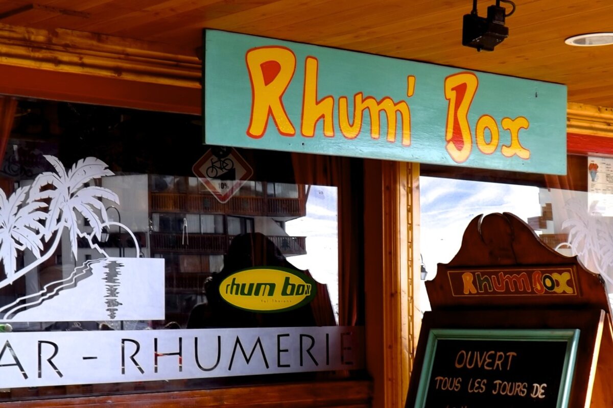 front of a bar with a green sign