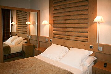 A hotel room with a bed and a mirror