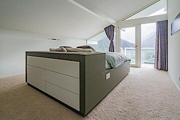 A bedroom with a bed and a large window