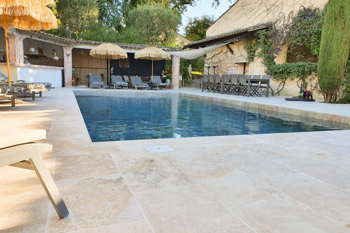 A large swimming pool surrounded by chairs and umbrellas