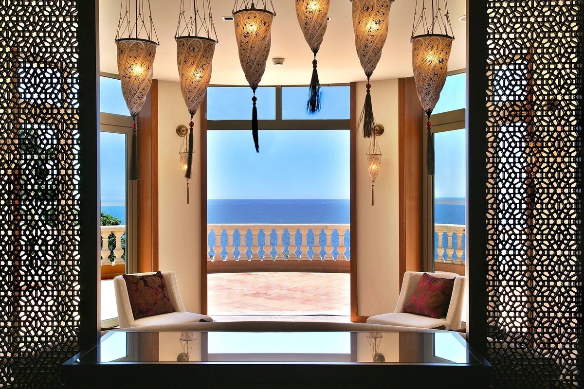 A room with a table and chairs with a view of the ocean