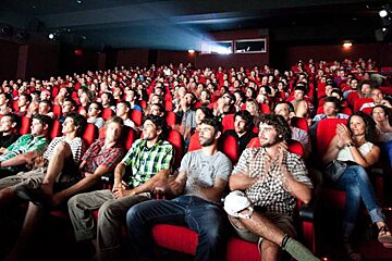 A crowd of people are watching a movie in a theater