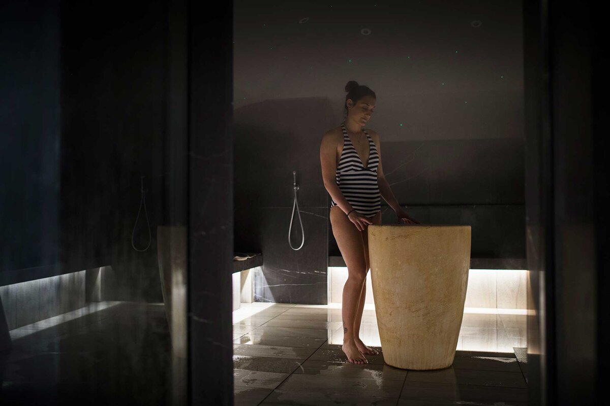 A woman in a bathing suit is standing in a dark room