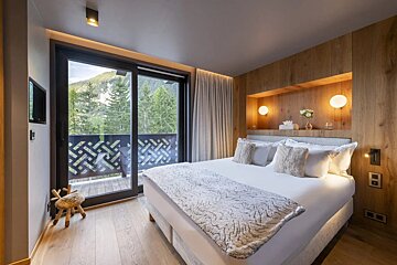 A bedroom with a large bed and a balcony