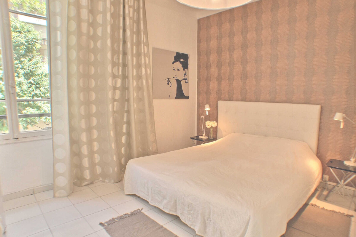A bedroom with a picture of audrey hepburn on the wall