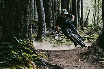 A man riding a bike on a trail in the woods