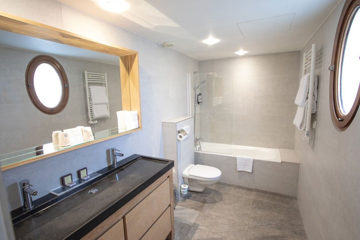 A bathroom with a toilet a sink and a mirror