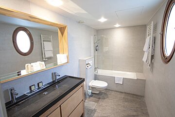 A bathroom with a toilet a sink and a mirror