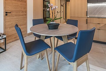A round table with blue chairs and a potted plant on it