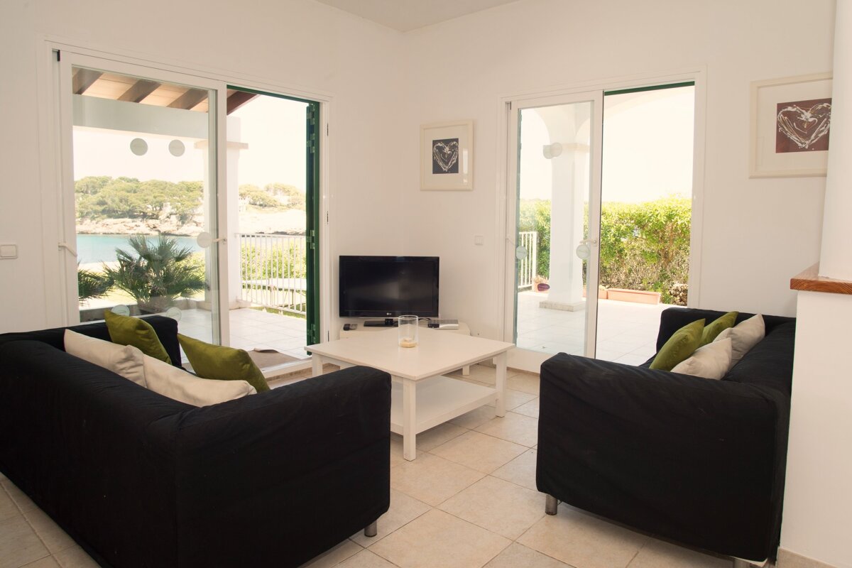 A living room with two black couches and a flat screen tv