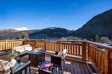 A balcony with a view of mountains and trees