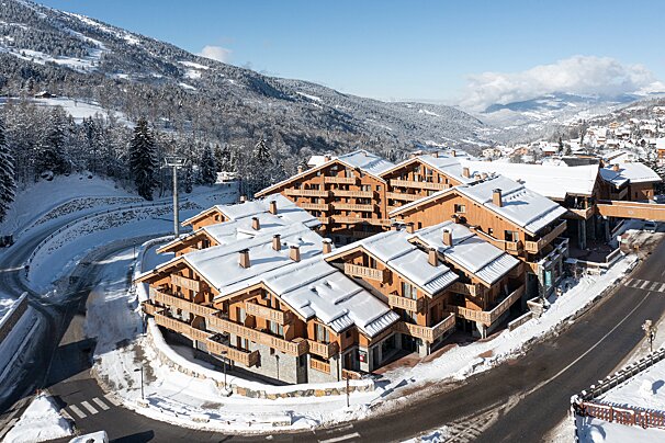 An aerial view of a ski resort with snow on the buildings