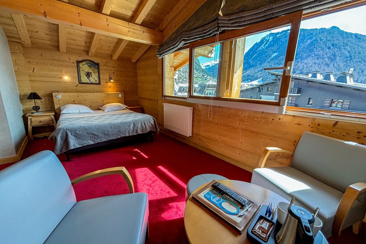 A hotel room with a bed a chair and a table