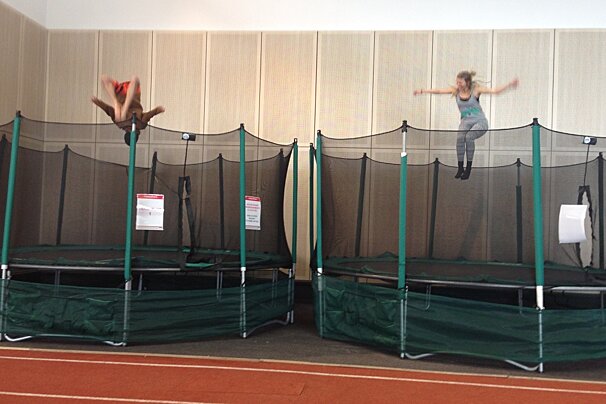 two people in the air on trampolines
