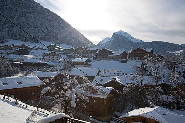 A snowy village with a mountain in the background