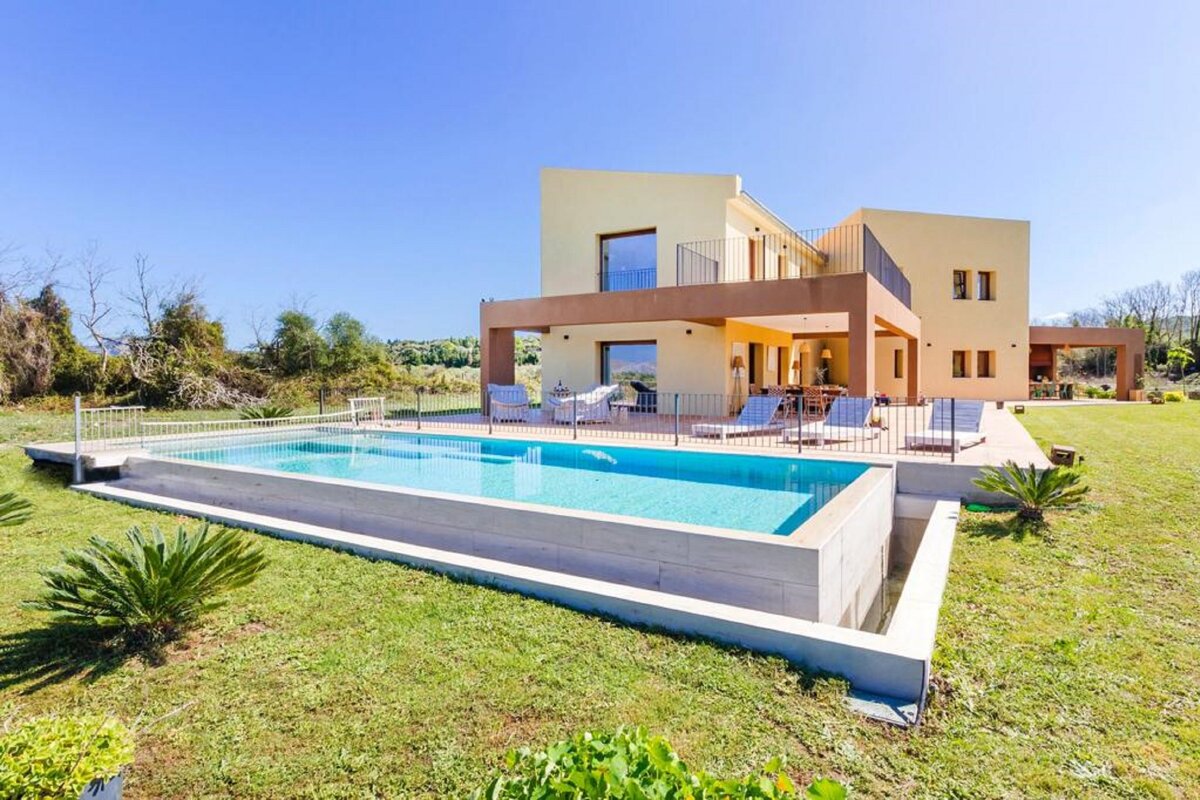 A large house with a large swimming pool in front of it