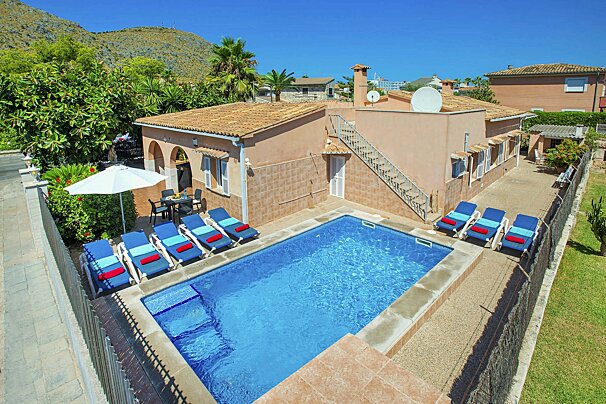 A house with a large swimming pool in front of it
