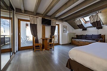A bedroom with a couch a table and a flat screen tv