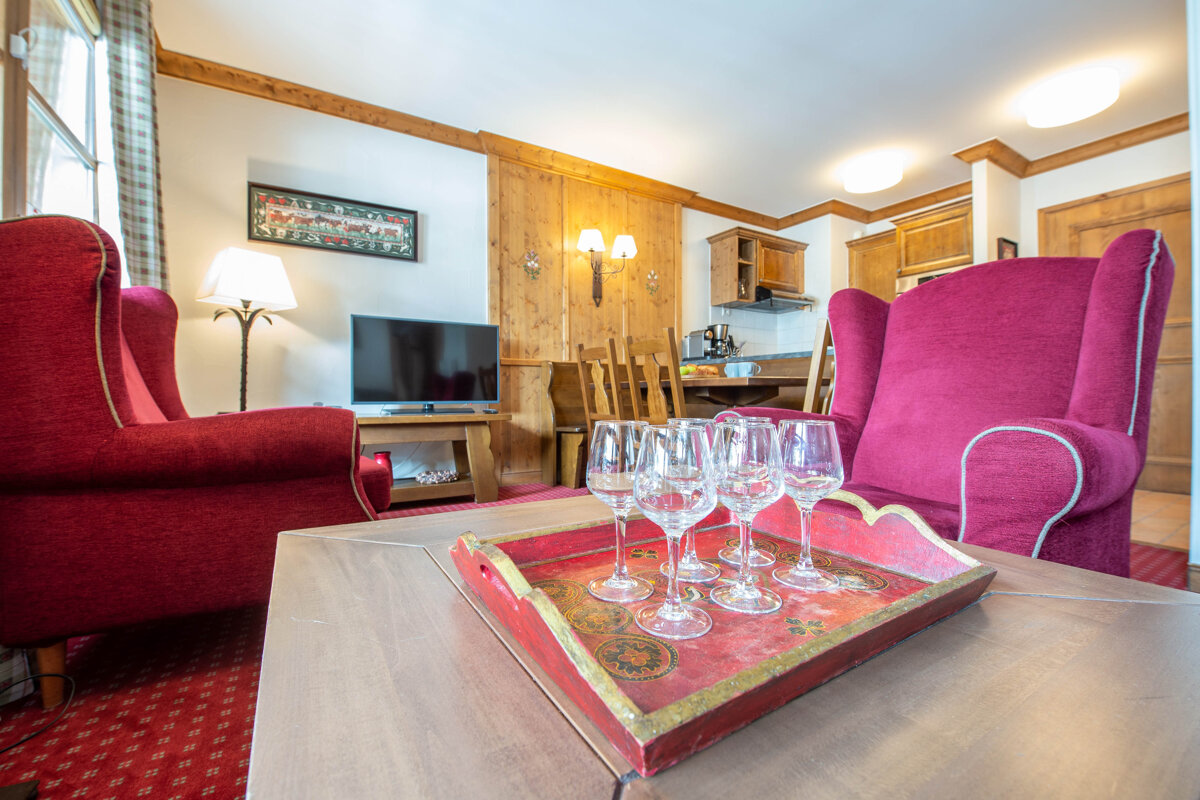 A tray of wine glasses sits on a table in a living room