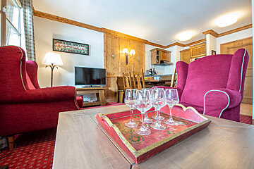 A tray of wine glasses sits on a table in a living room