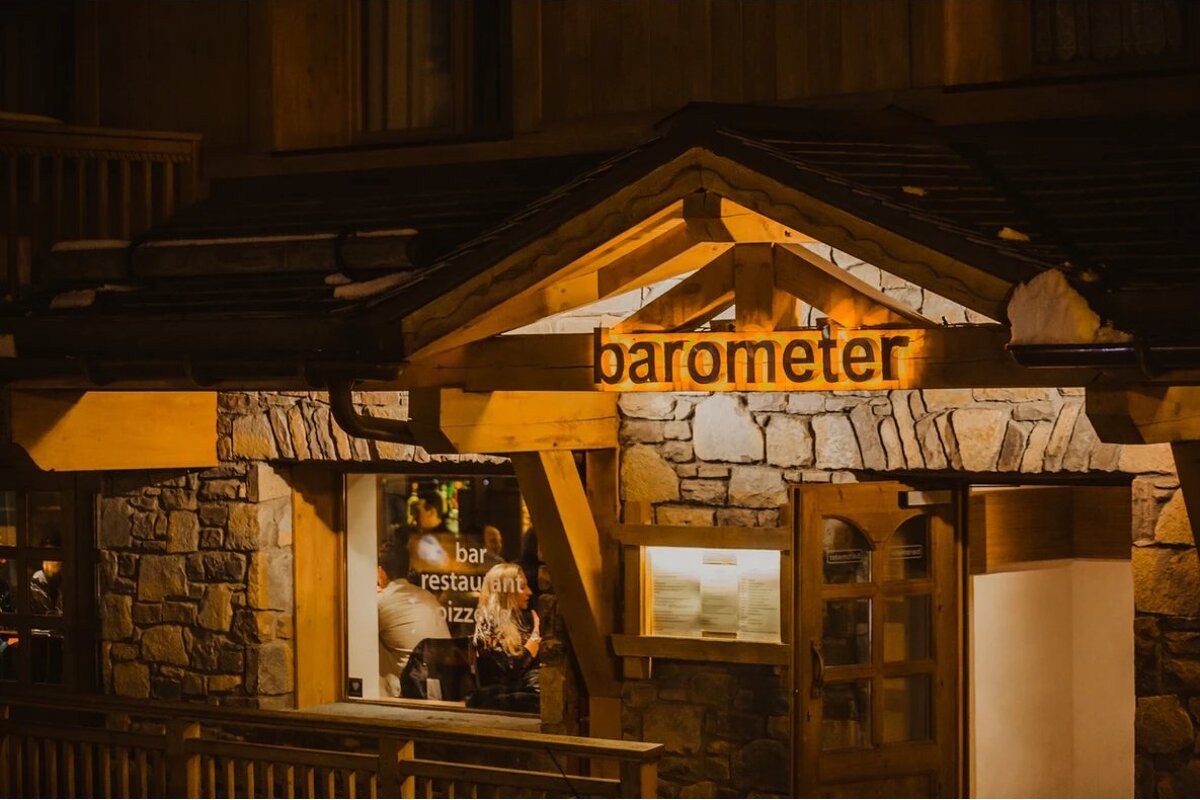 A restaurant called barometer is lit up at night