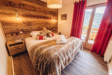 A bedroom with a large bed and red curtains