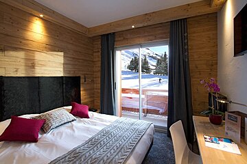 A hotel room with a bed and a desk