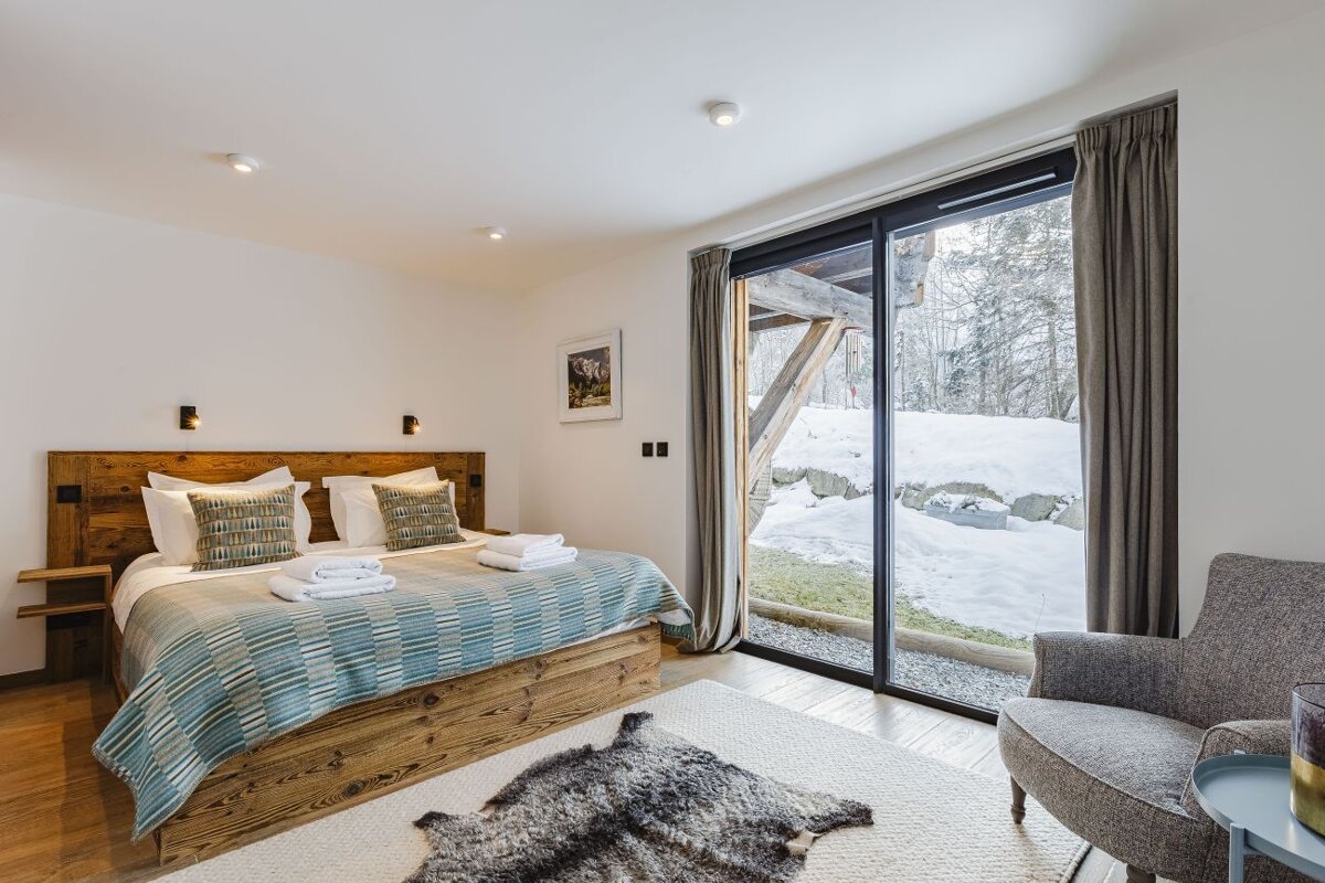 A bedroom with a large bed and a sliding glass door