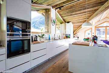 A kitchen with white cabinets and a blue siemens oven