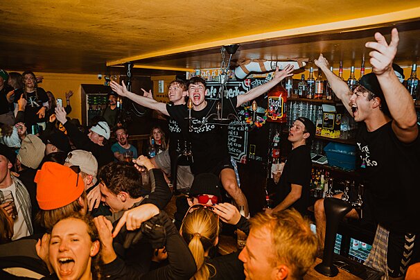 A group of people in a bar wearing shirts that say cafe secko