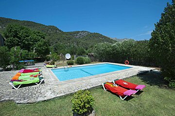 A swimming pool surrounded by lawn chairs and a satellite dish