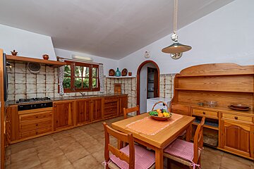 A kitchen with wooden cabinets and a table with fruit on it
