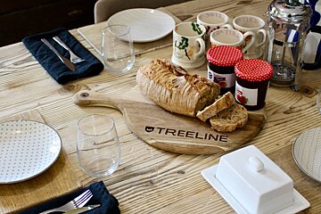 A wooden cutting board with the word treeline on it