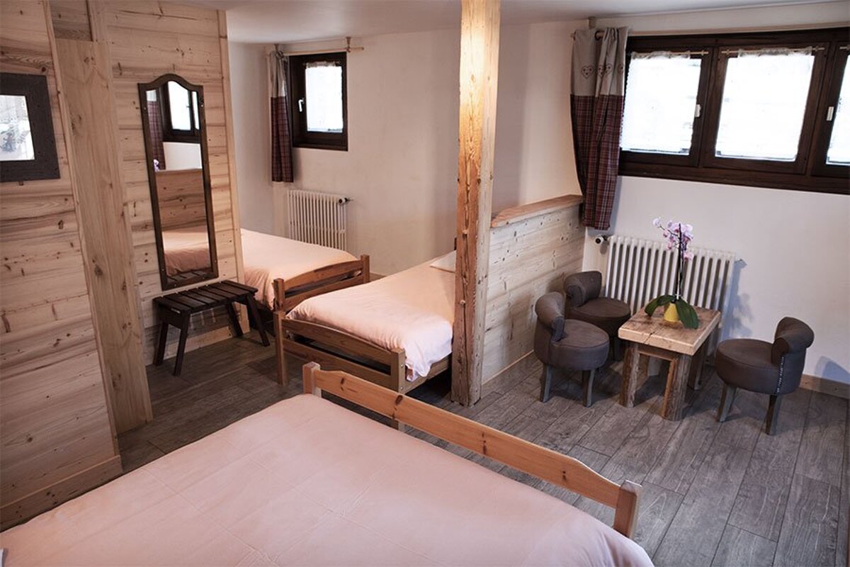 A bedroom with two beds and a table and chairs