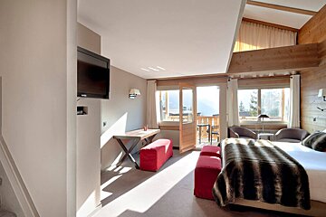 A hotel room with a large bed and a flat screen tv