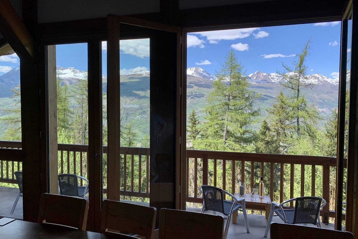 A balcony with a view of mountains and trees