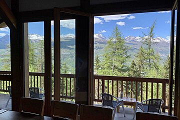 A balcony with a view of mountains and trees