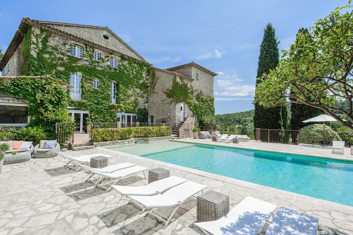 A large house with a swimming pool in front of it