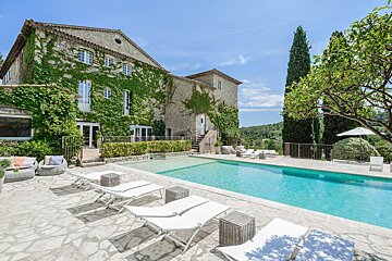 A large house with a swimming pool in front of it