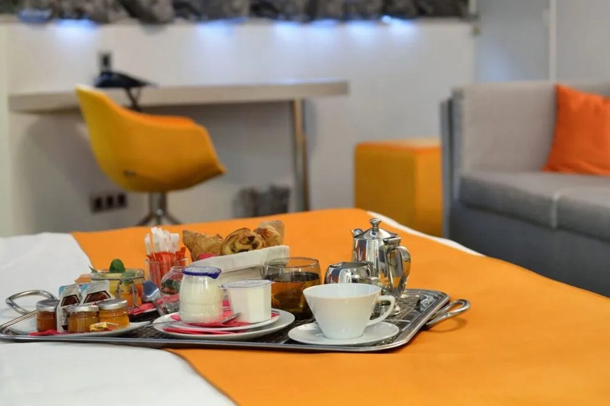 A tray of food on a bed including a cup of coffee