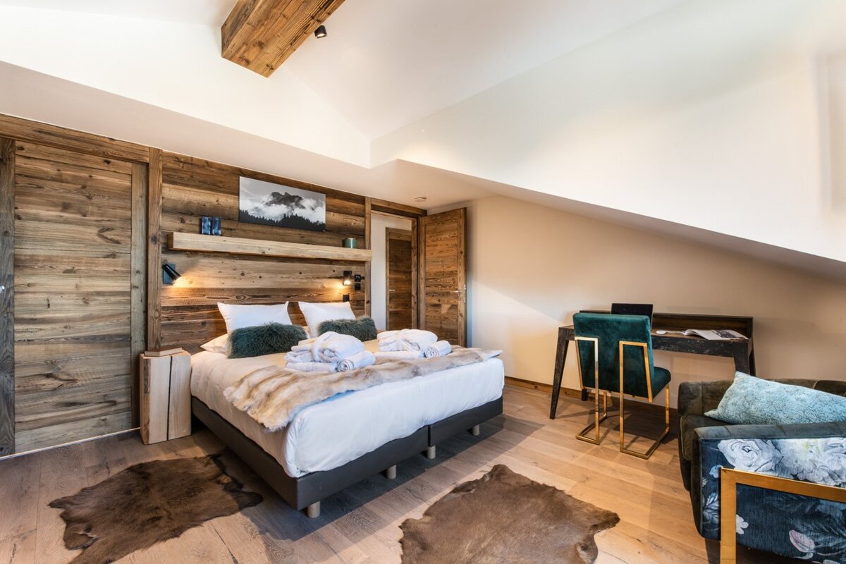 A bedroom with a large bed and a desk