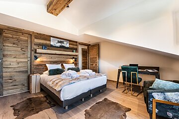 A bedroom with a large bed and a desk