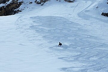 a skier in parallel powder tracks