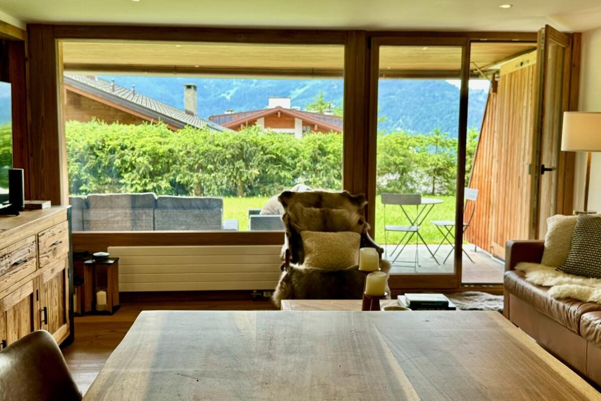 A living room with a table and chairs and a view of the mountains
