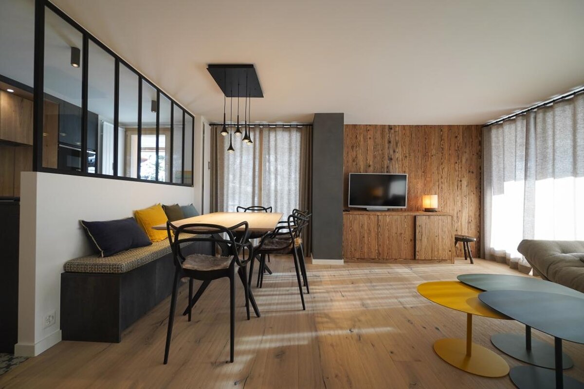 A living room with a table and chairs and a television