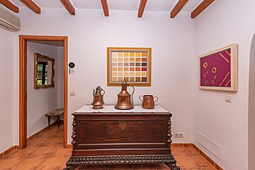 A room with a wooden trunk and a picture on the wall