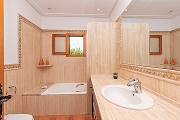 A bathroom with a sink a toilet and a window