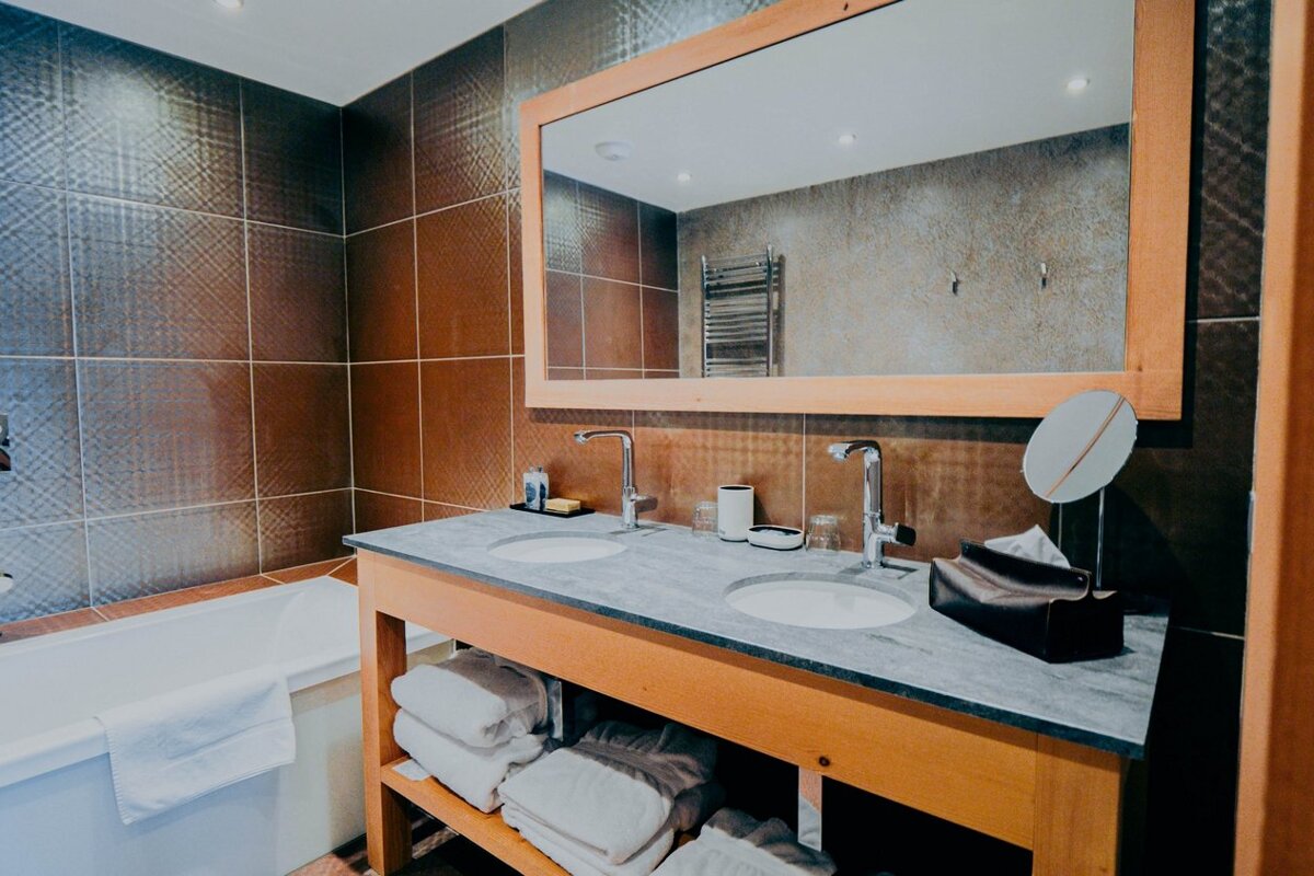 A bathroom with two sinks and a large mirror